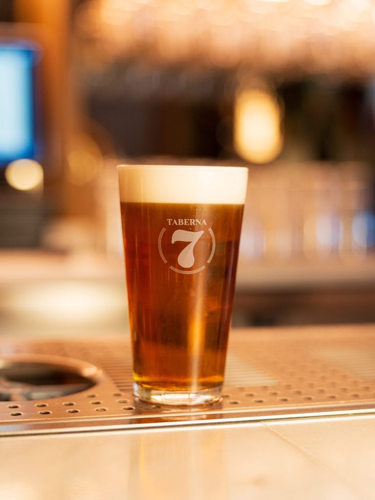 Caña de cerveza bien fría en vaso de Taberna 7 sobre la barra